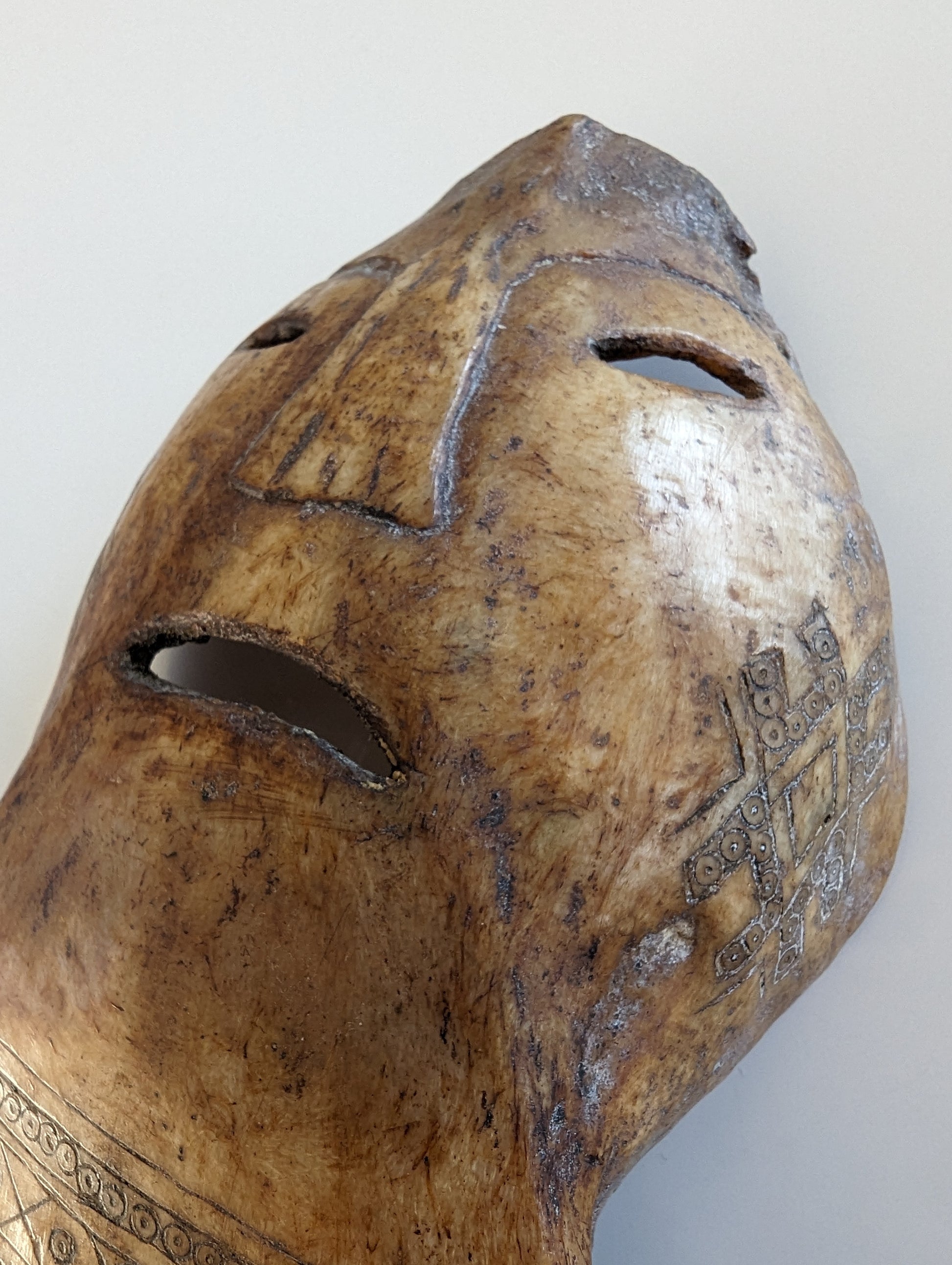 Side Profile: A side profile shot of the amulet's face, showing the raised, carved features