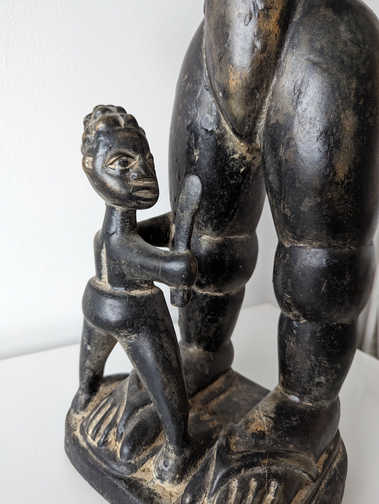 Photo of the carve yoruba statue representing a child at the feet of his mother