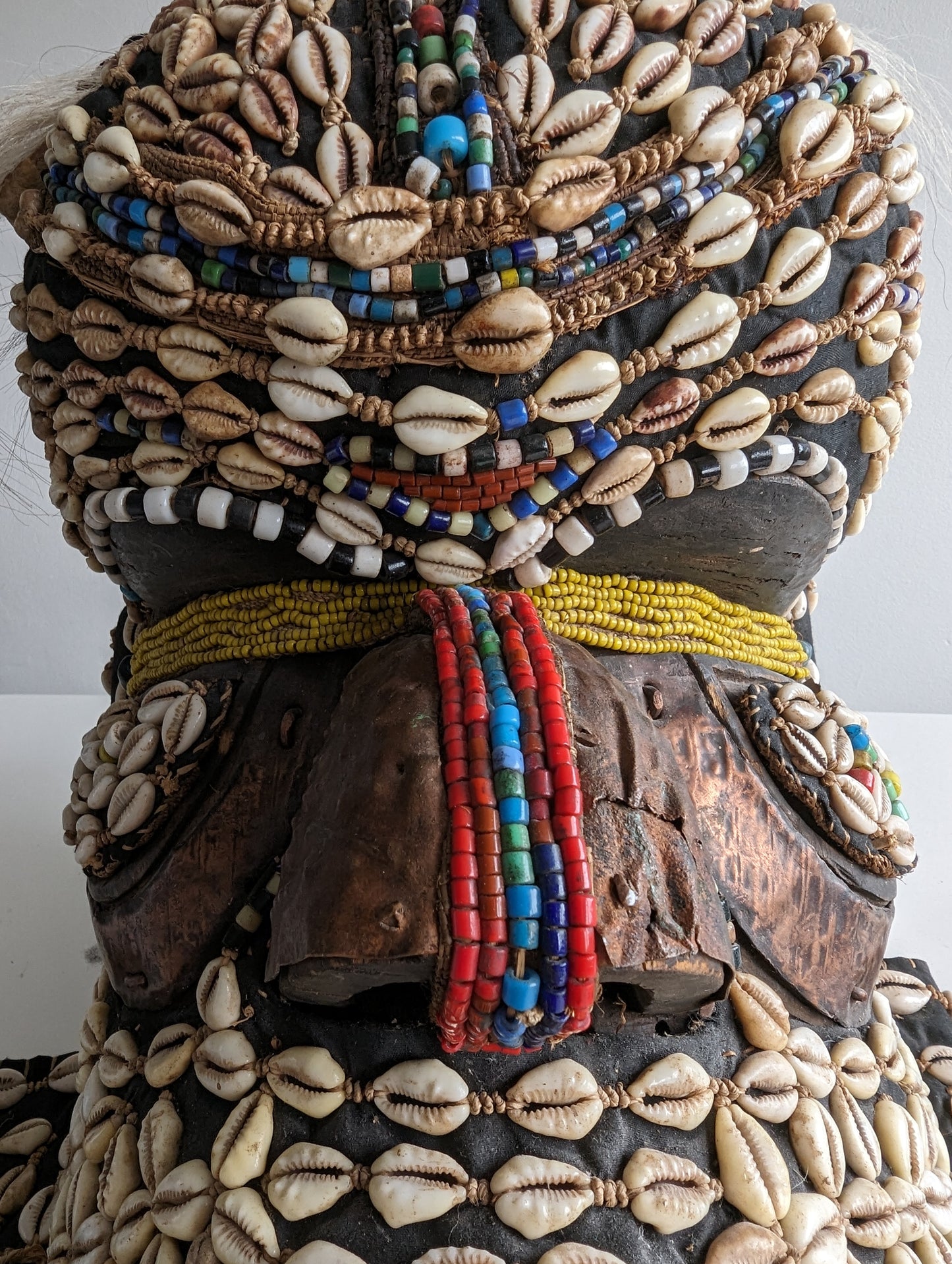 A side profile of the mask, showing the depth of the decorations and the materials used on the face, head, and neck flaps.