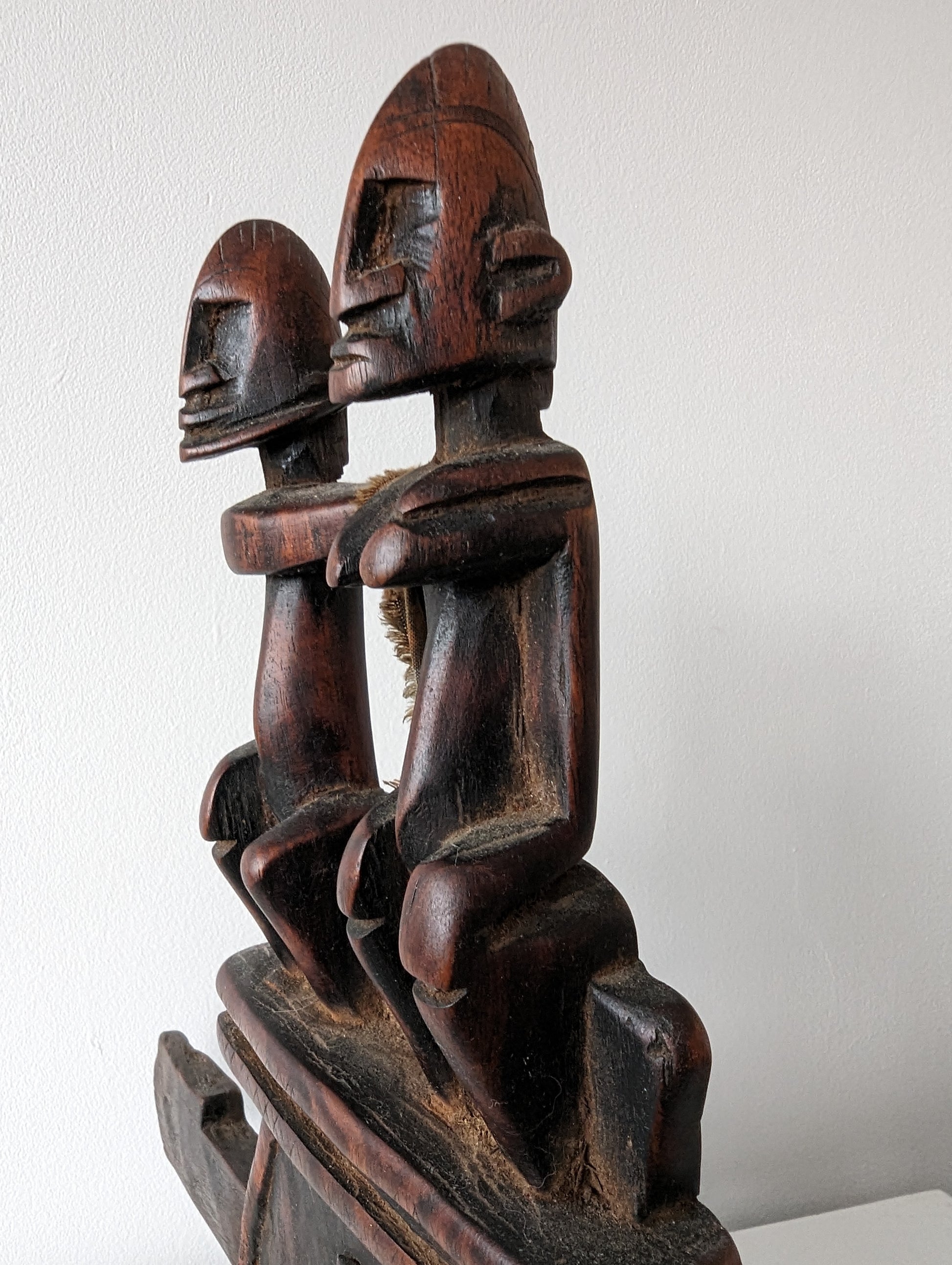 n angled, close-up view of the Dogon lock, highlighting the intricate carving of the couple at the top and the detail of the central face.