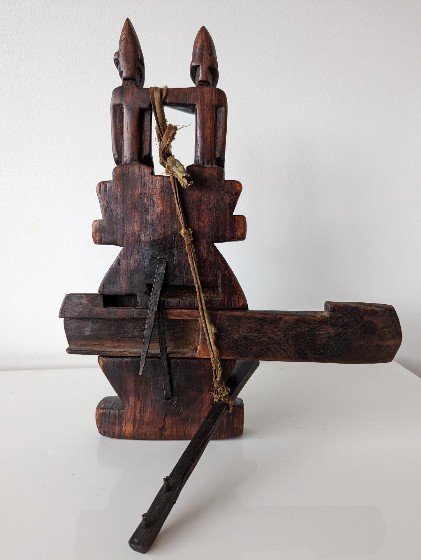 A view of the back of the Dogon lock, showing the key inserted and the rustic, textured surface of the wood.