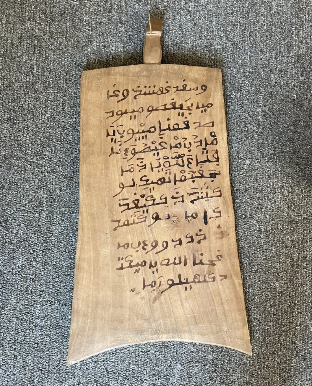 A wooden Islamic writing board, also known as a Lawh, with Arabic script in black ink on both sides, including a handle tab at the top.