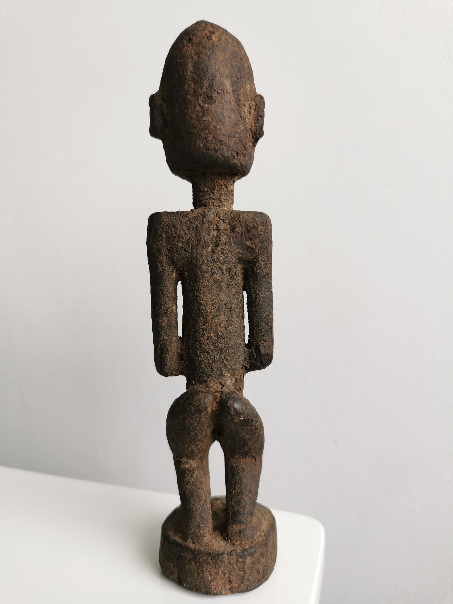 Full-body back view of the Lobi figure, highlighting its straight posture and the detail of its carved head and hands.