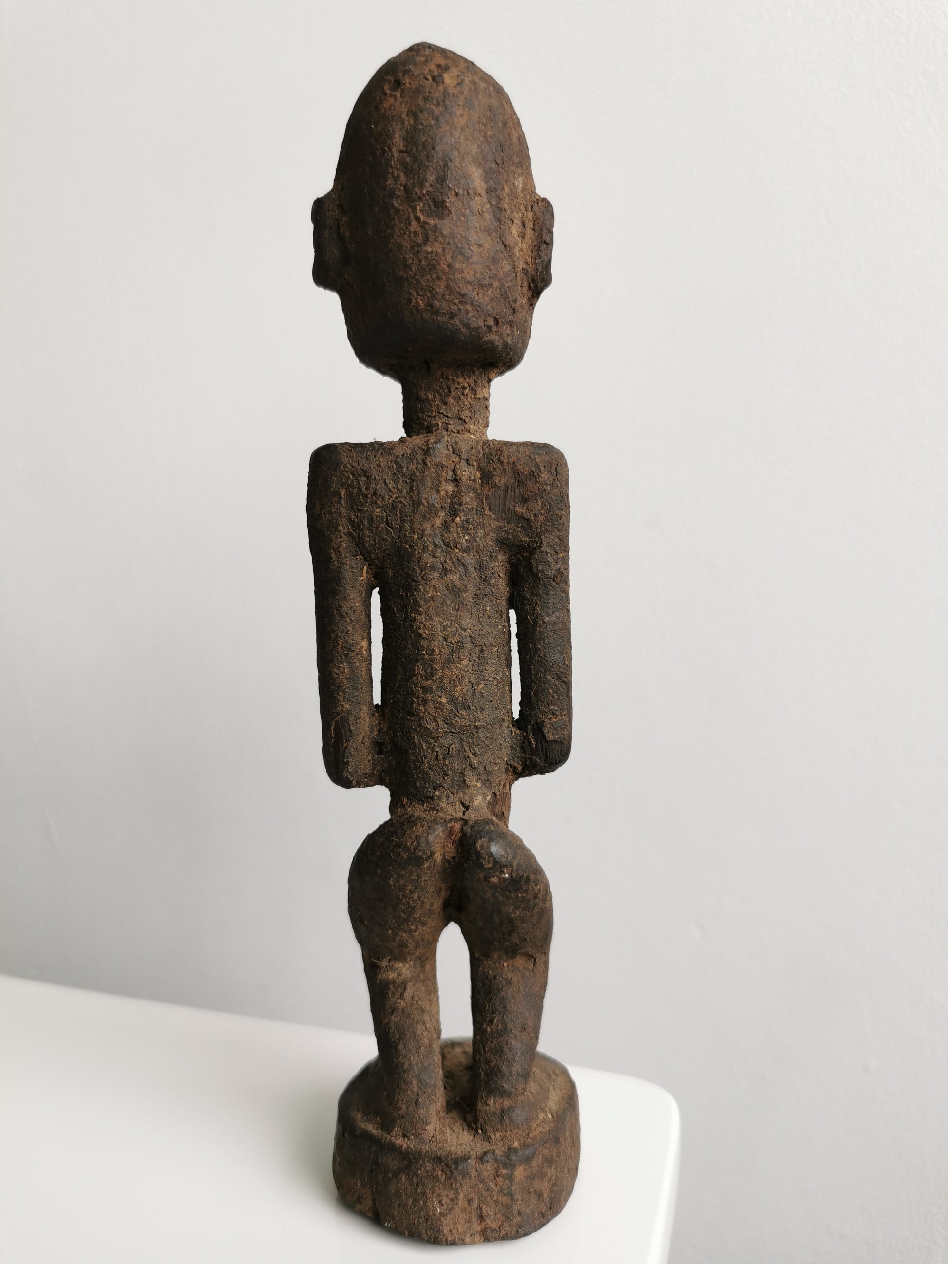 Full-body back view of the Lobi figure, highlighting its straight posture and the detail of its carved head and hands.