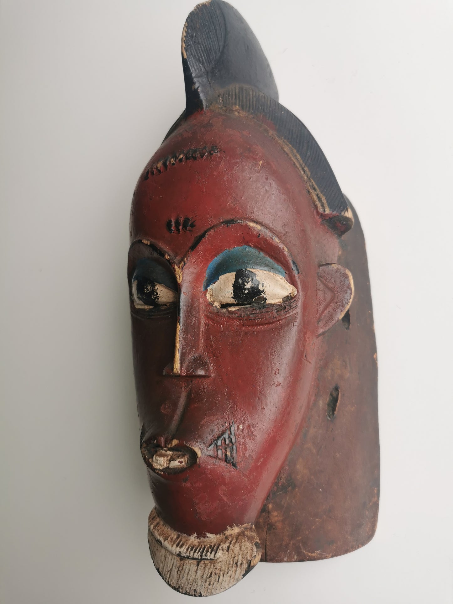 A side profile of the Guro mask, showing its narrow form and the slight curve of the face.