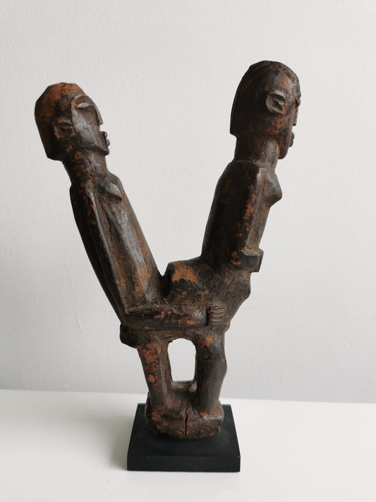 This captivating wooden statue, crafted by the Lobi people of Burkina Faso, depicts a couple engaged in a sexual act.